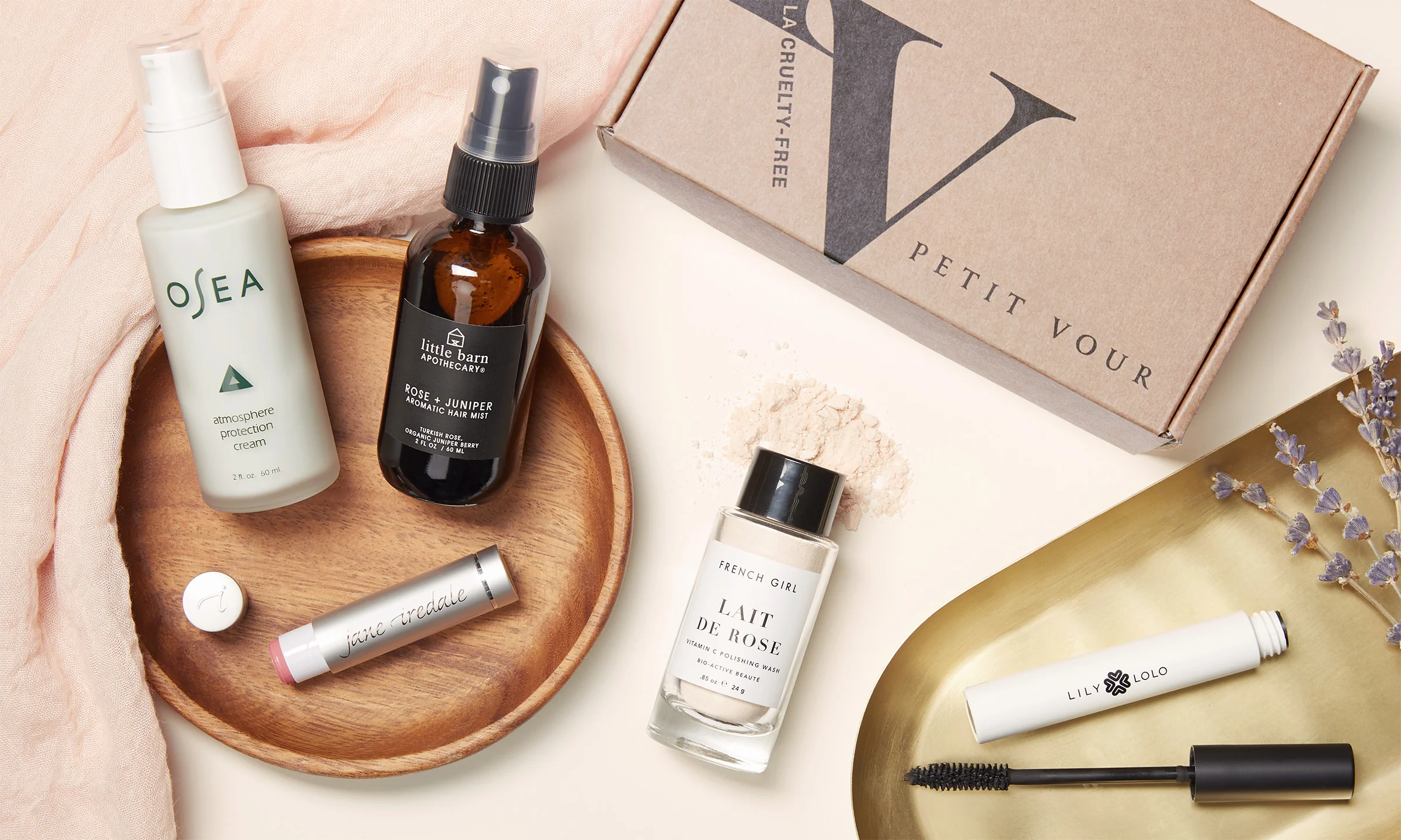 Petit Vour cruelty-free beauty box with five vegan skincare products displayed beside it on a minimalist surface.