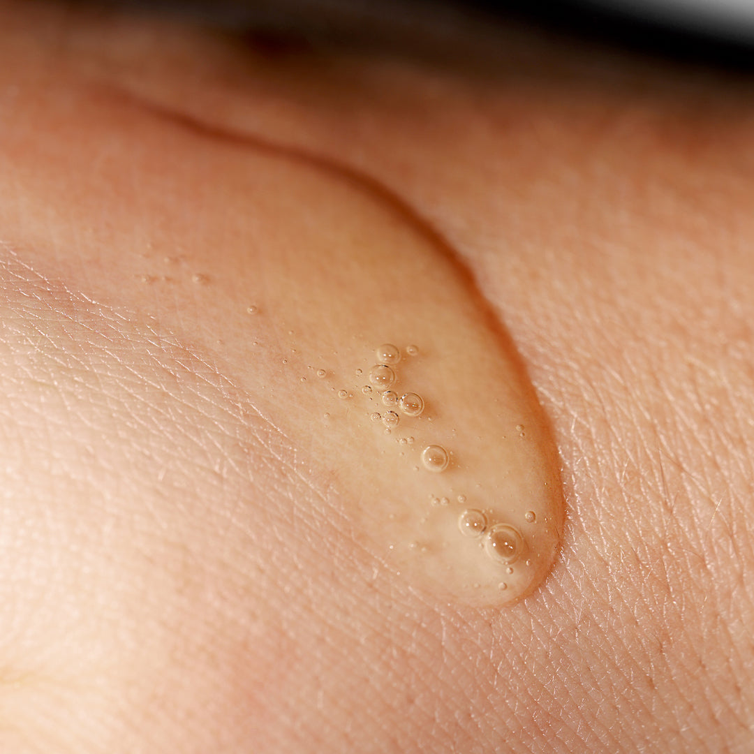 AYUNA | Longeva | Texture Close-up Image - translucent beige serum with small air bubbles on skin