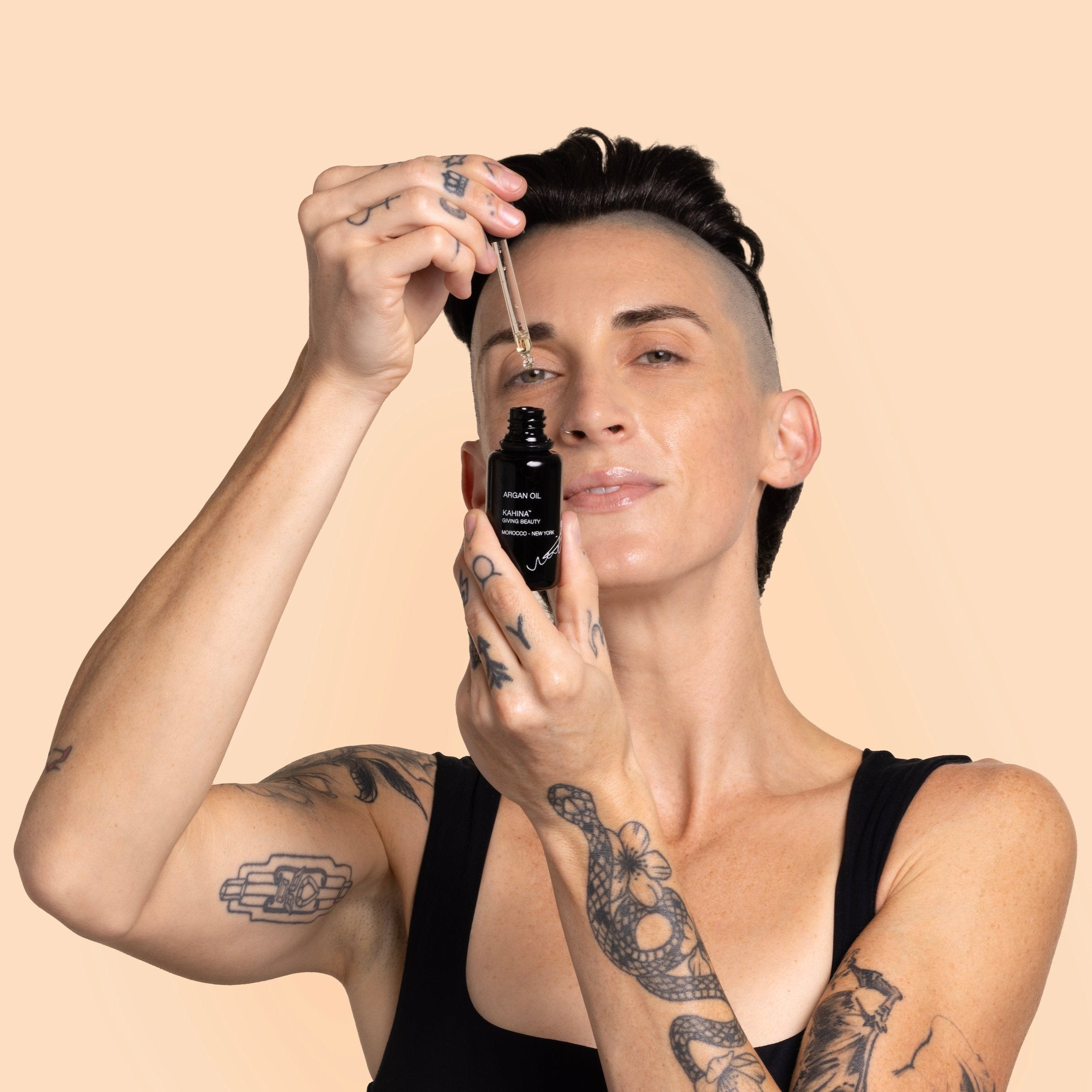 Beauty Heroes Model opening a bottle of Kahina Giving Beauty Argan Oil