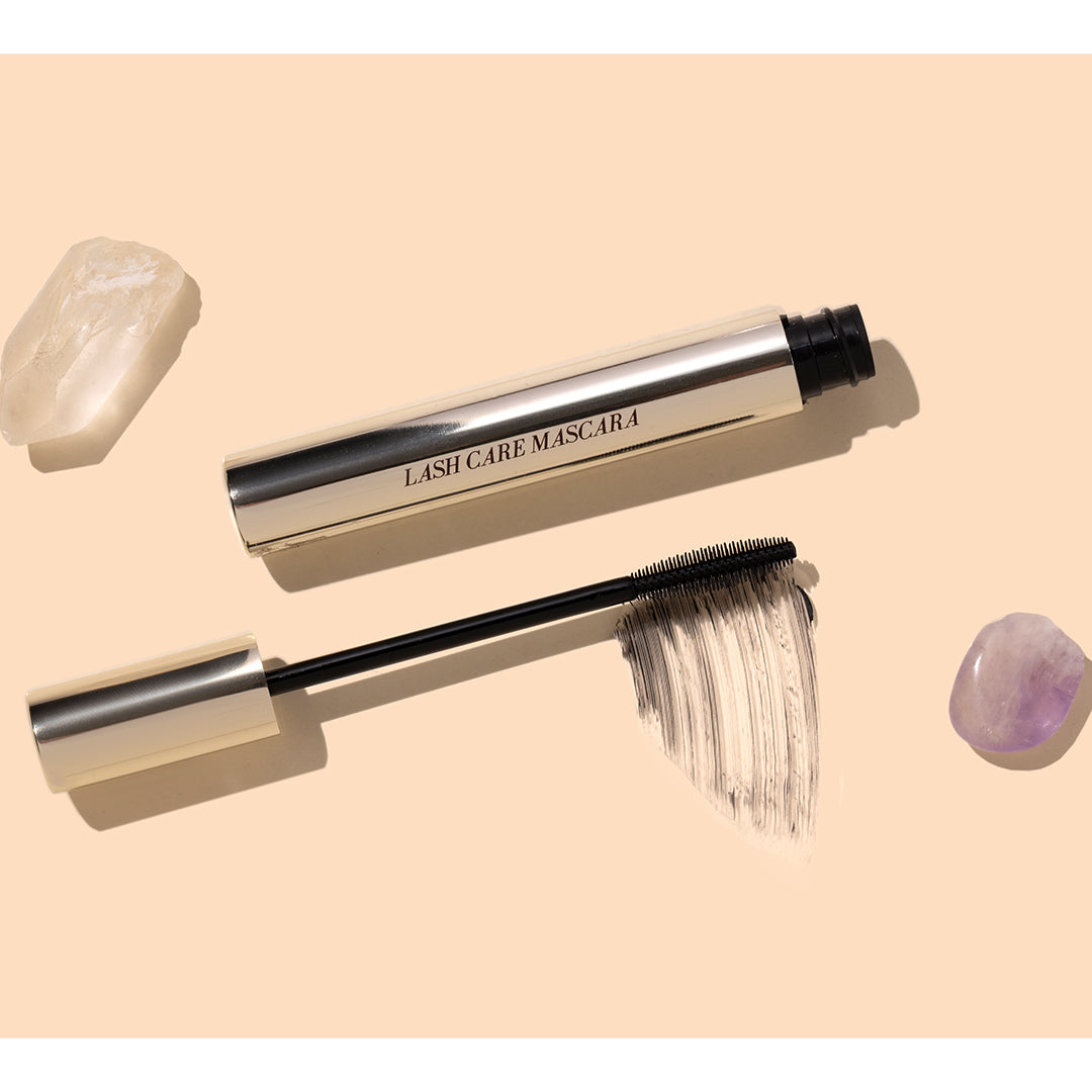 Fitglow | Lash Care Mascara | Styled Image with Swatch_Oct26 - mascara with wand, black swatch, and crystals on a peach background