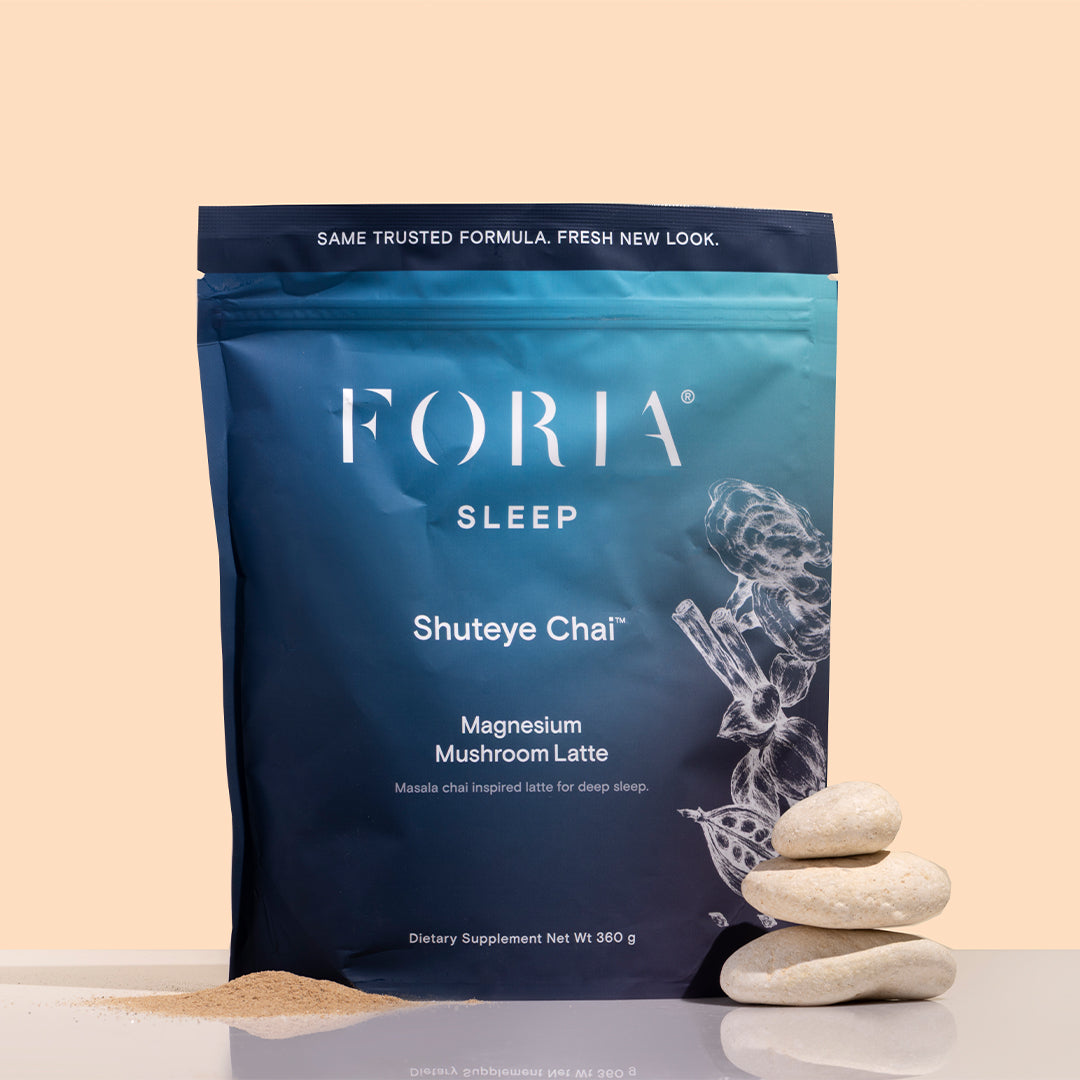 Foria | Shuteye Chai | Styled Image_Oct26 - blue pouch with powder and stacked stones on a peach background