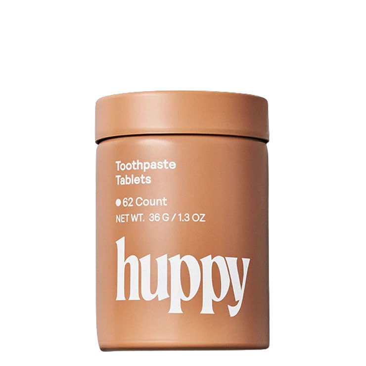 Container of huppy toothpaste tablets on a white background