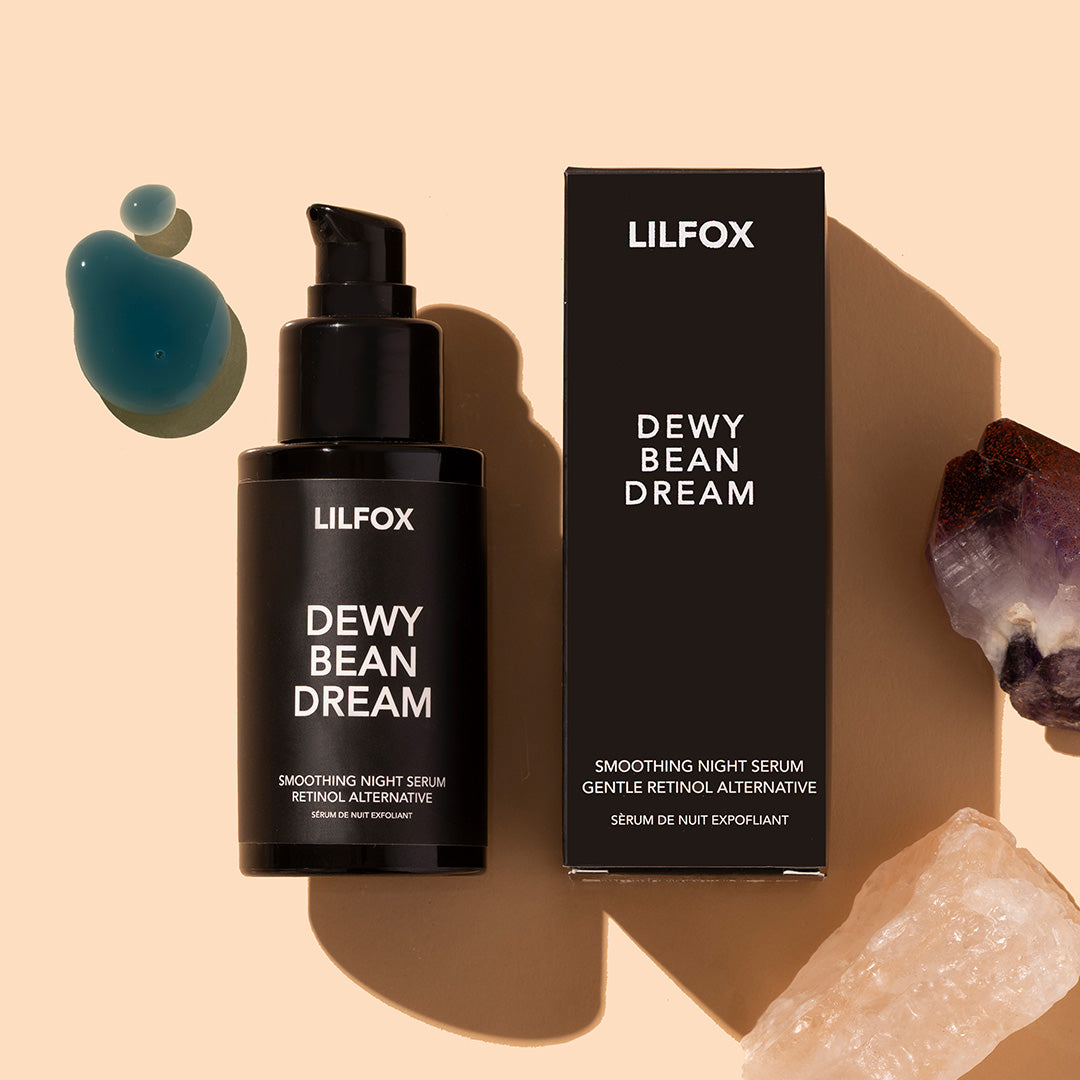 LILFOX | Dewy Bean Dream | Styled image flat lay with swatch, black bottle and black box with blue product swatch on peach background