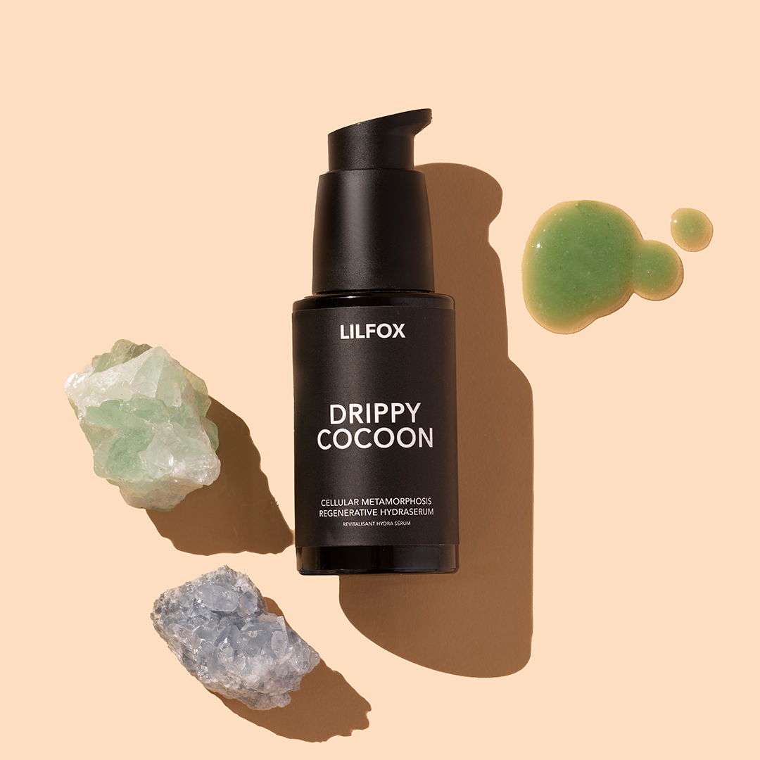 LILFOX | Drippy Cocoon | Product Image with Swatch - black pump bottle with green swatch and crystal stones on a beige background