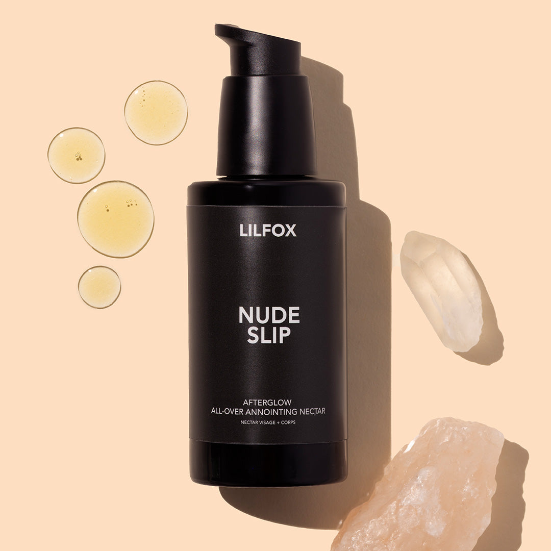 LILFOX | Nude Slip | Styled image with swatch | Black bottle on peach background with yellow product drops