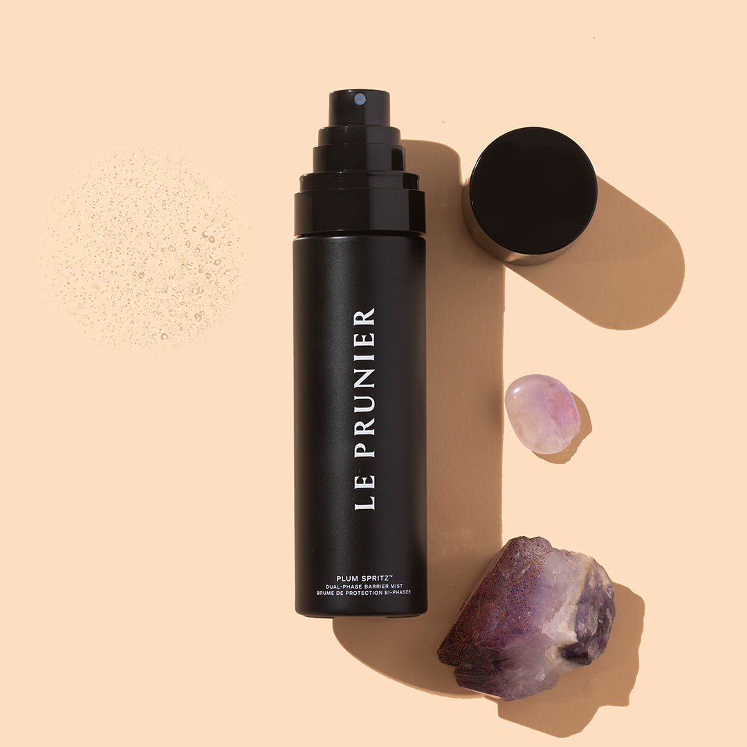 Le Prunier | Plum Spritz | Styled Image - mist bottle with cap, crystals, and water droplets on a beige background