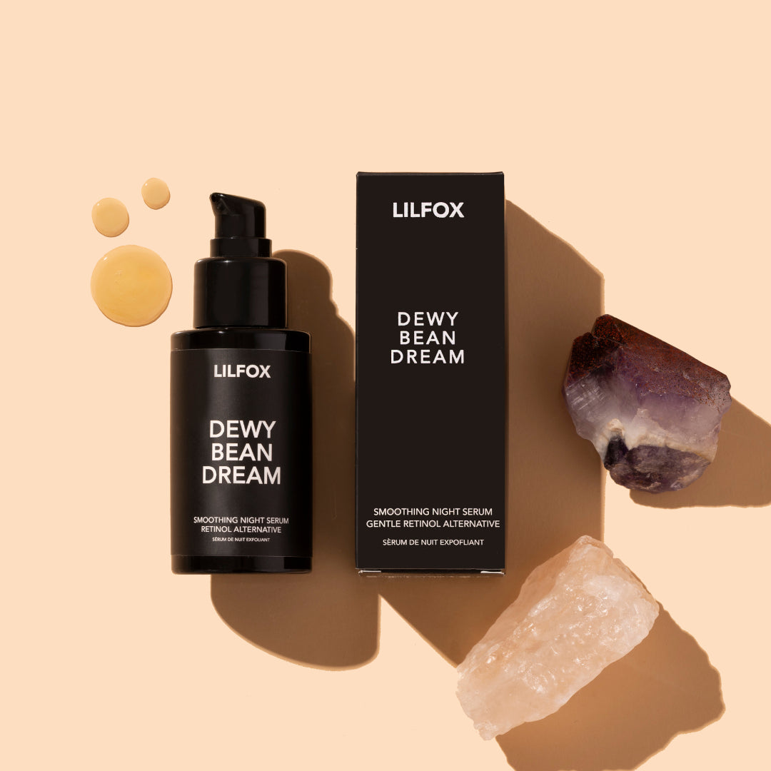 Lilfox | Dewy Bean Dream | Product Image with Swatch - bottle with box, serum drops, and crystals on a warm beige background