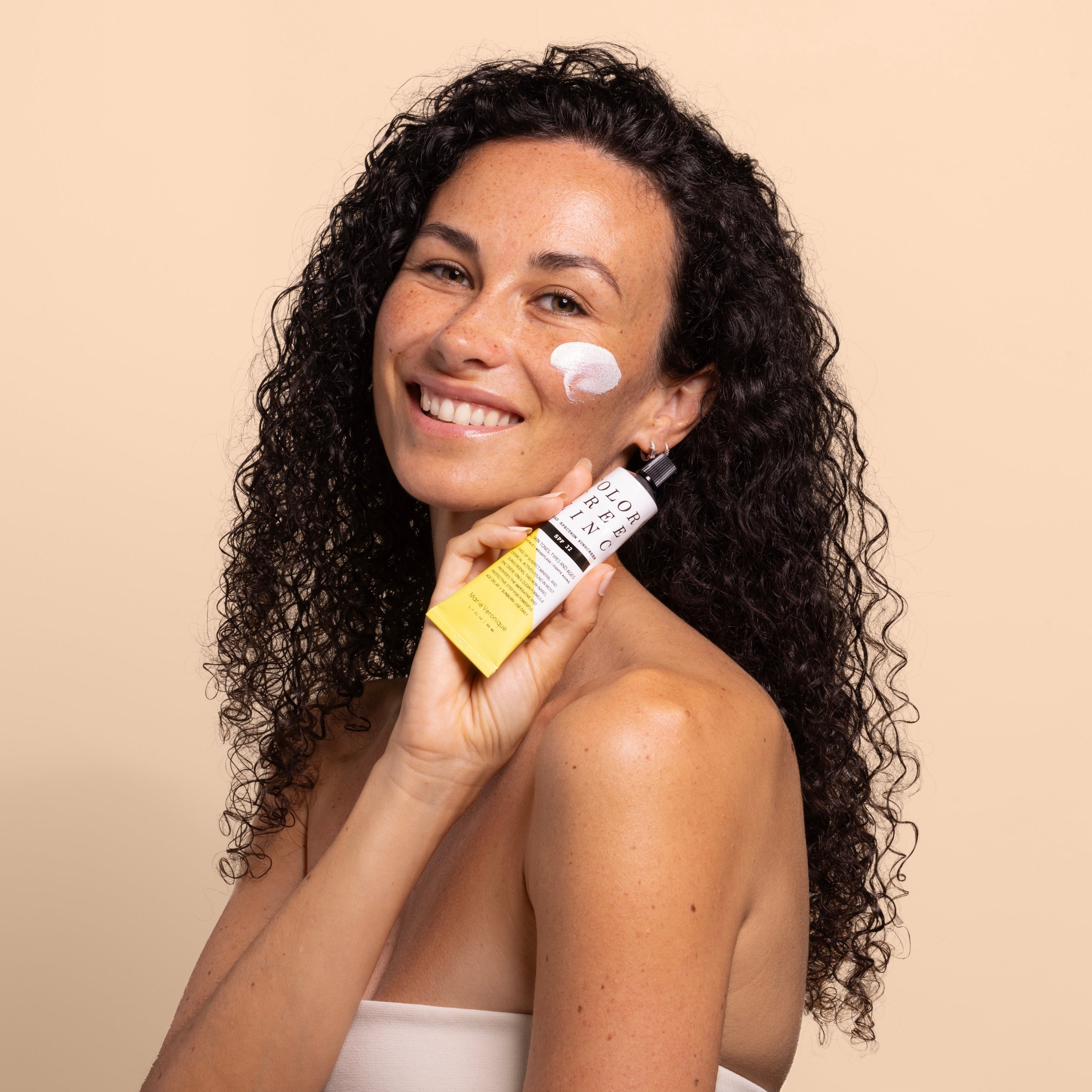 Marie Veronique ColorFree Zinc SPF with model holding against beige background