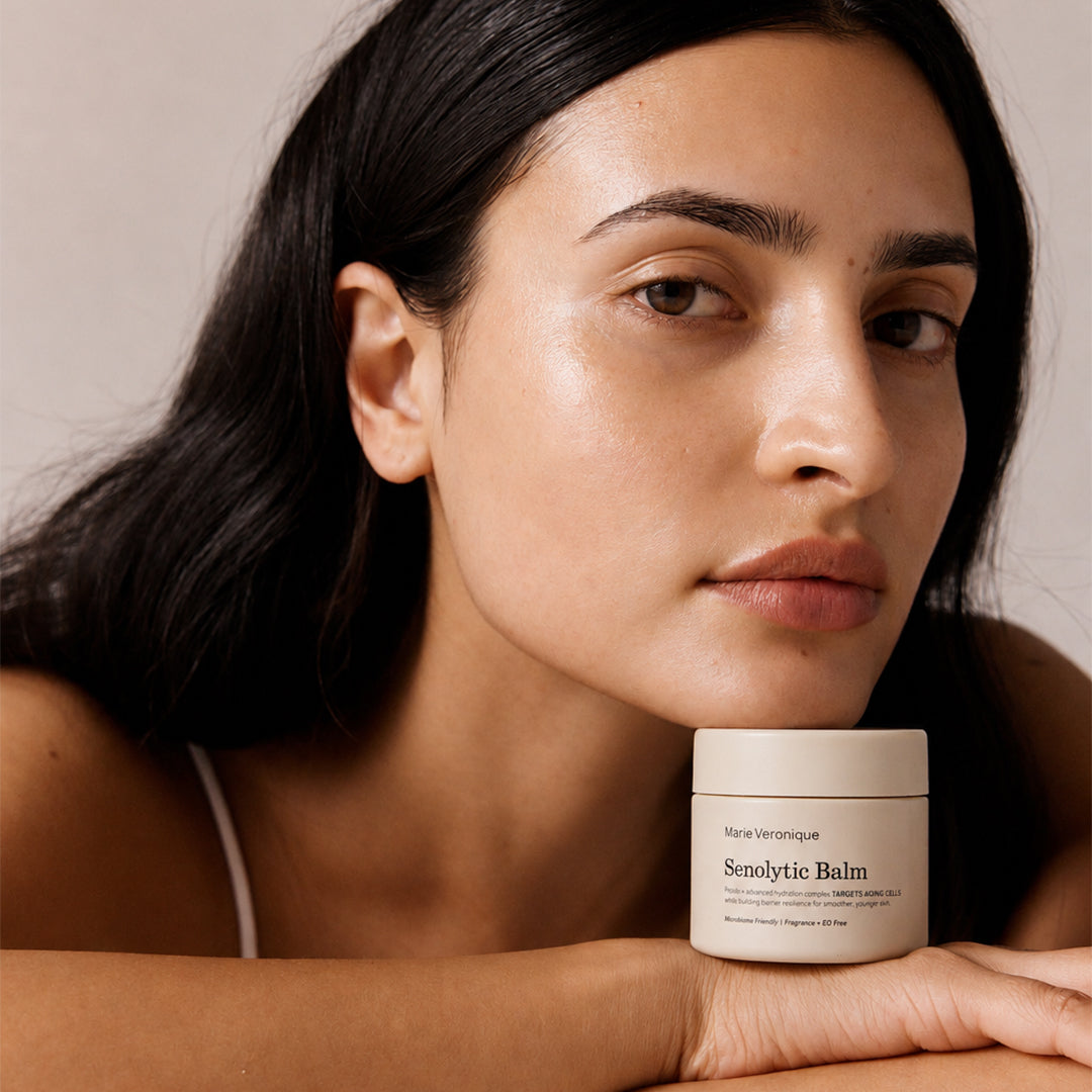 Marie Veronique | Senolytic Balm | Model Image - model posing with Marie Veronique Senolytic Balm against a neutral background