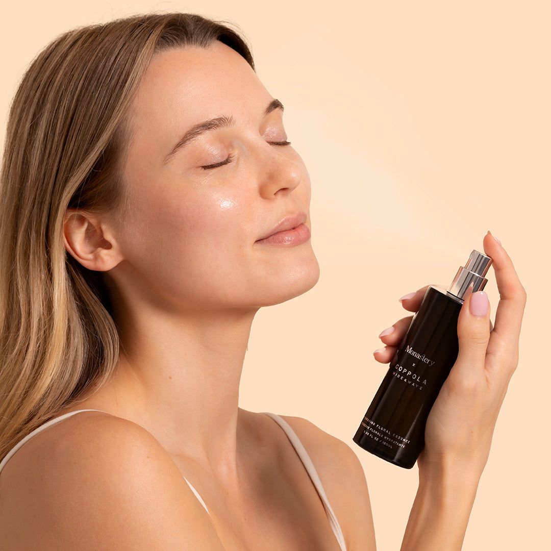 Monastery | Coppola Hideaways Mist | Model Image | women holding black bottle, misting face