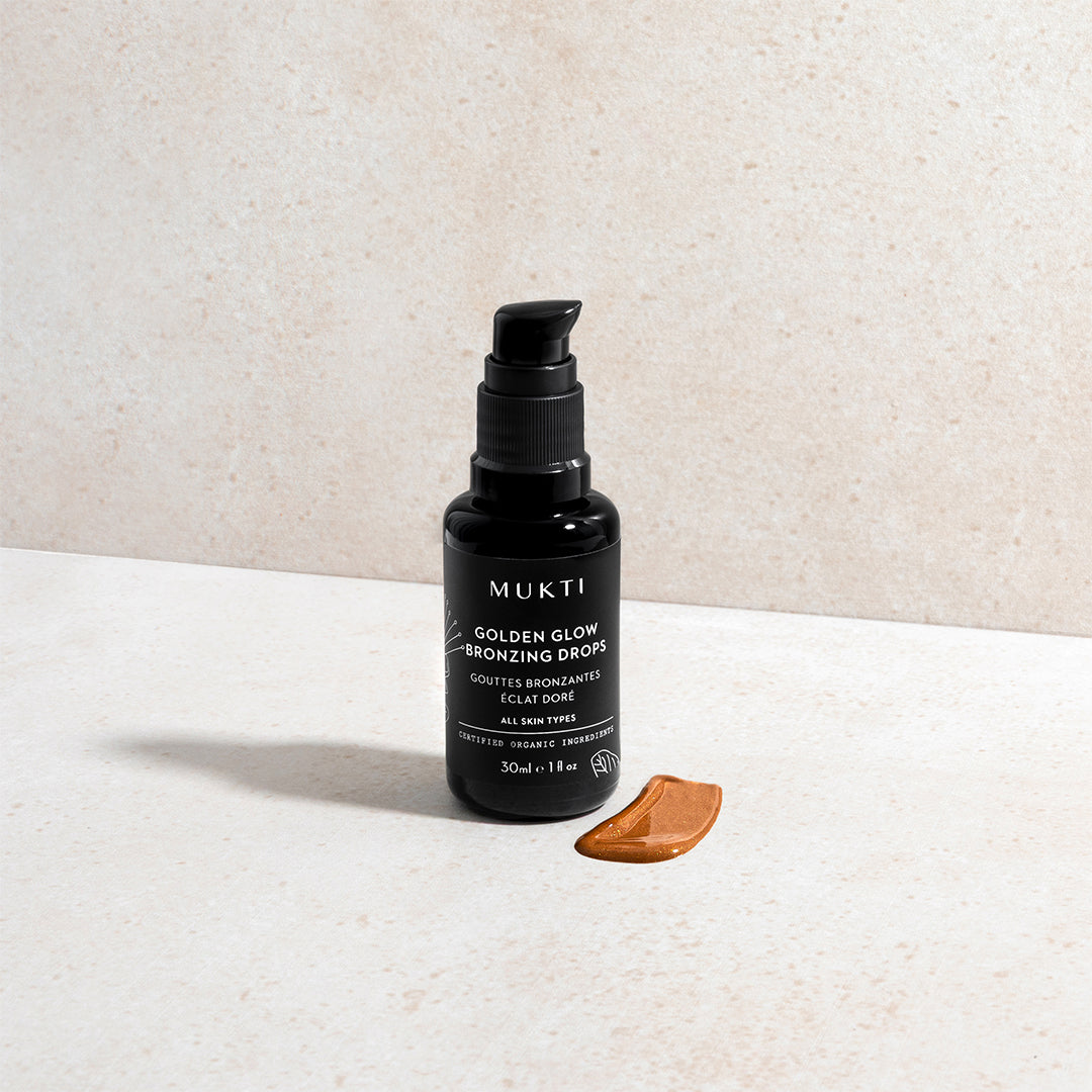 Mukti | Golden Glow Bronzing Drops | Styled Image with Swatch - Golden Glow Bronzing Drops with a product swatch.