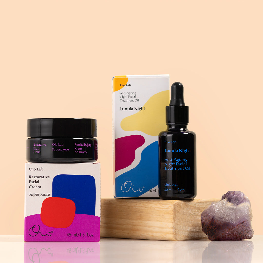 Oio Lab | Discovery Box Collection | Styled Image - Oio Lab Lunula Night Facial Treatment Oil and Superpause Facial Cream with boxes and crystal against a beige background