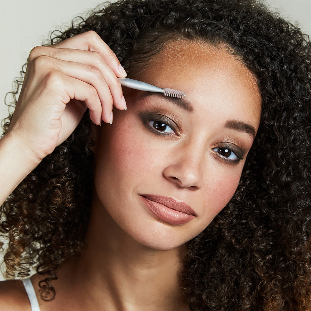 RMS Beauty | Back2Brow Brush | Model Image - model brushing eyebrows while wearing natural makeup