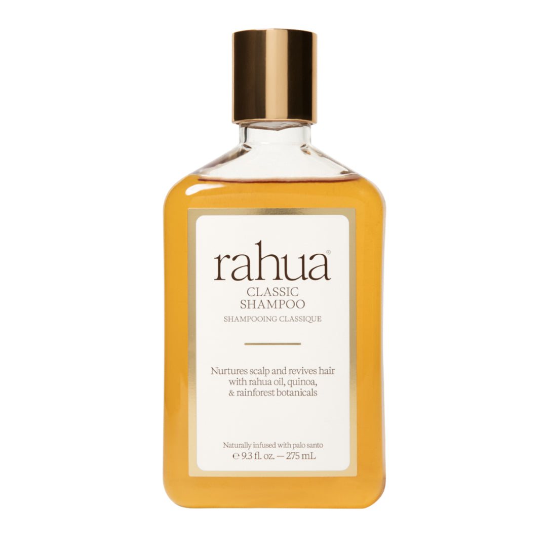 Rahua | Classic Shampoo | Product Image - bottle filled with golden shampoo and topped with a metallic gold cap, displayed against a white background