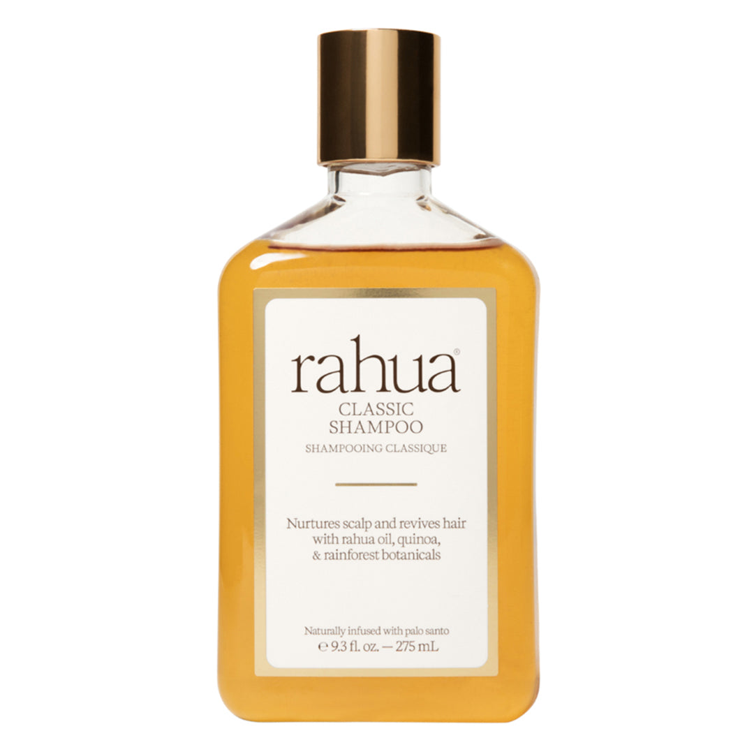 Rahua | Classic Shampoo | Product Image - bottle filled with golden shampoo and topped with a metallic gold cap, displayed against a white background