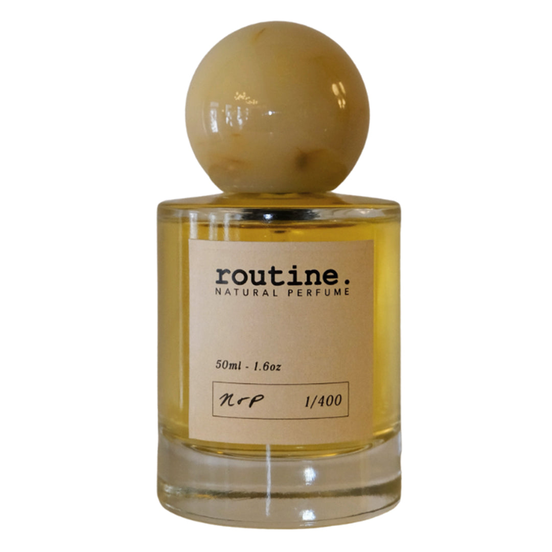 Routine | Natural Perfume Vol.1 | Product Image - bottle with golden liquid, beige label, and round beige cap on a white background