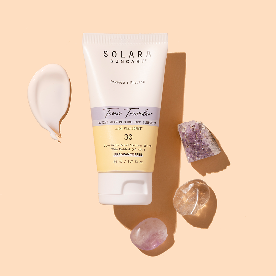 Solara Suncare | Time Traveler Active Wear Peptide Face Moisturizer SPF 30 | Product Image with Swatch - tube with cream swatch and crystals on a beige background