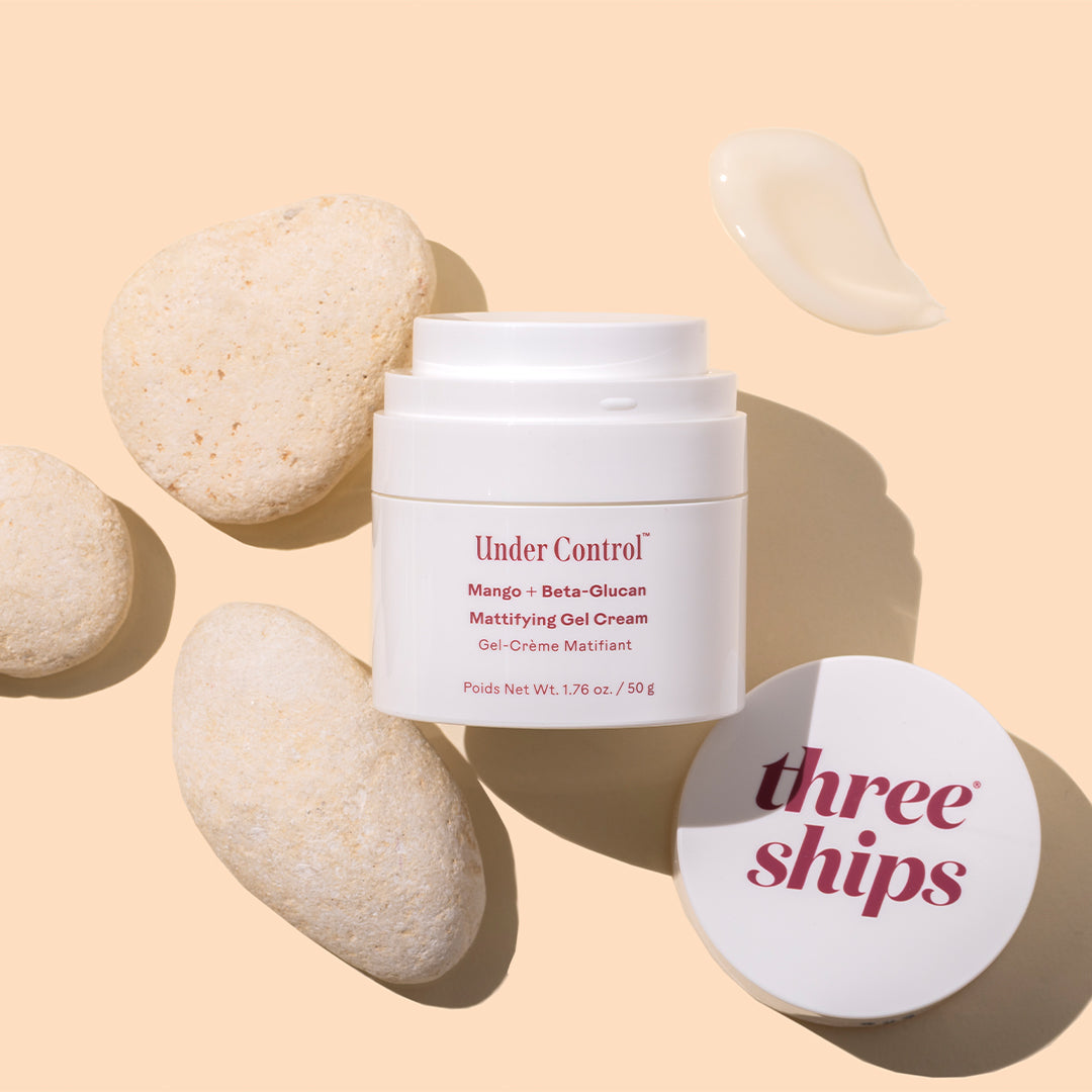 Three Ships | Mattifying Oil-Free Cream | Styled Image with Swatch_Sep26 - white jar with cream swatch and white stones on a peach background