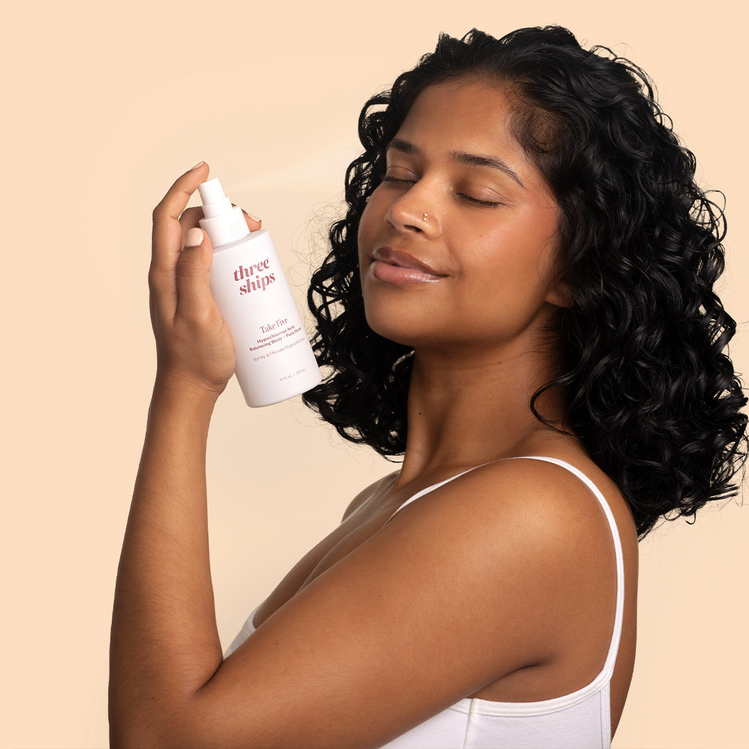Three Ships | Take Five | Model Image - person holding spray beside face with eyes closed against a neutral background