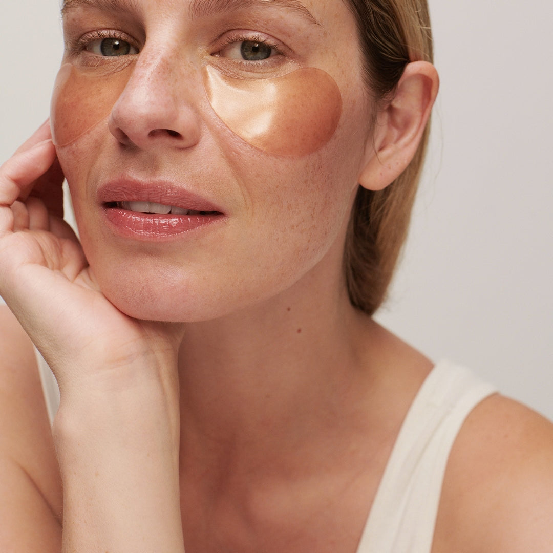True Botanicals | Eye Collection | Chebula Multi-Corrective Model Image - model wearing eye patches under the eyes.
