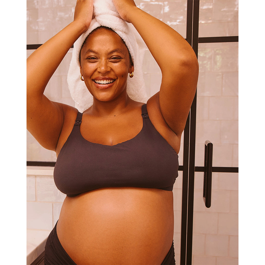 True Botanicals | Mindful Mama Belly & Body Oil | Pregnant Model Image1 - pregnant person smiling with a towel wrapped around their hair after bathing