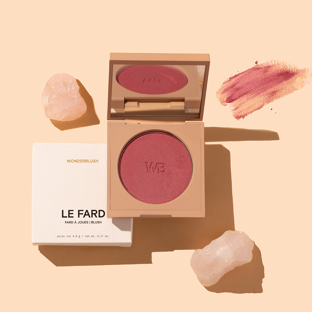 Wonderblush | Le Fard Blush | Product Image with Swatch - open compact of blush with box, swatch, and crystals on a beige background