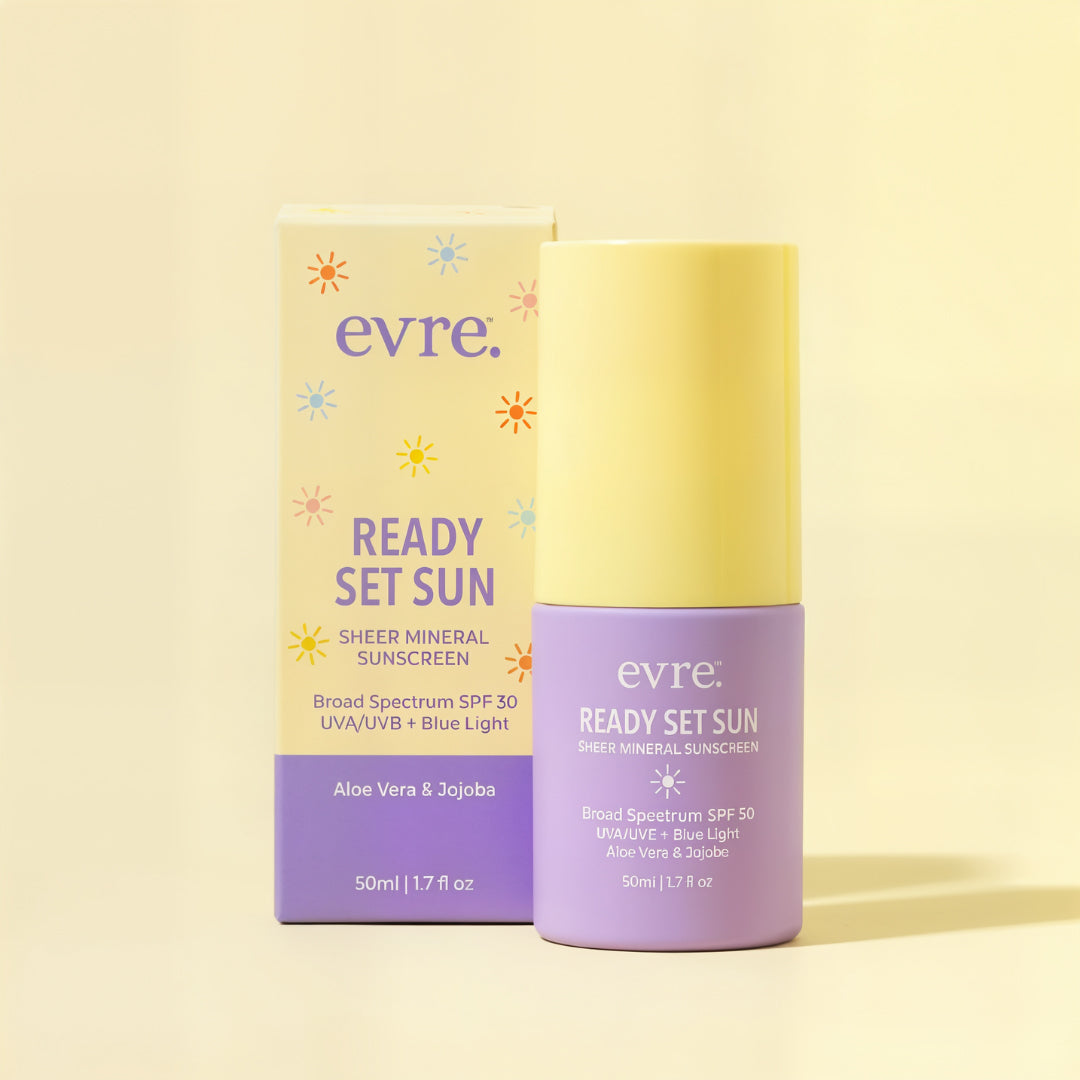 evre. | Ready Set Sun Sheer Mineral Sunscreen | Packaging Image - lavender bottle beside its matching pastel yellow and lavender box on a soft yellow background