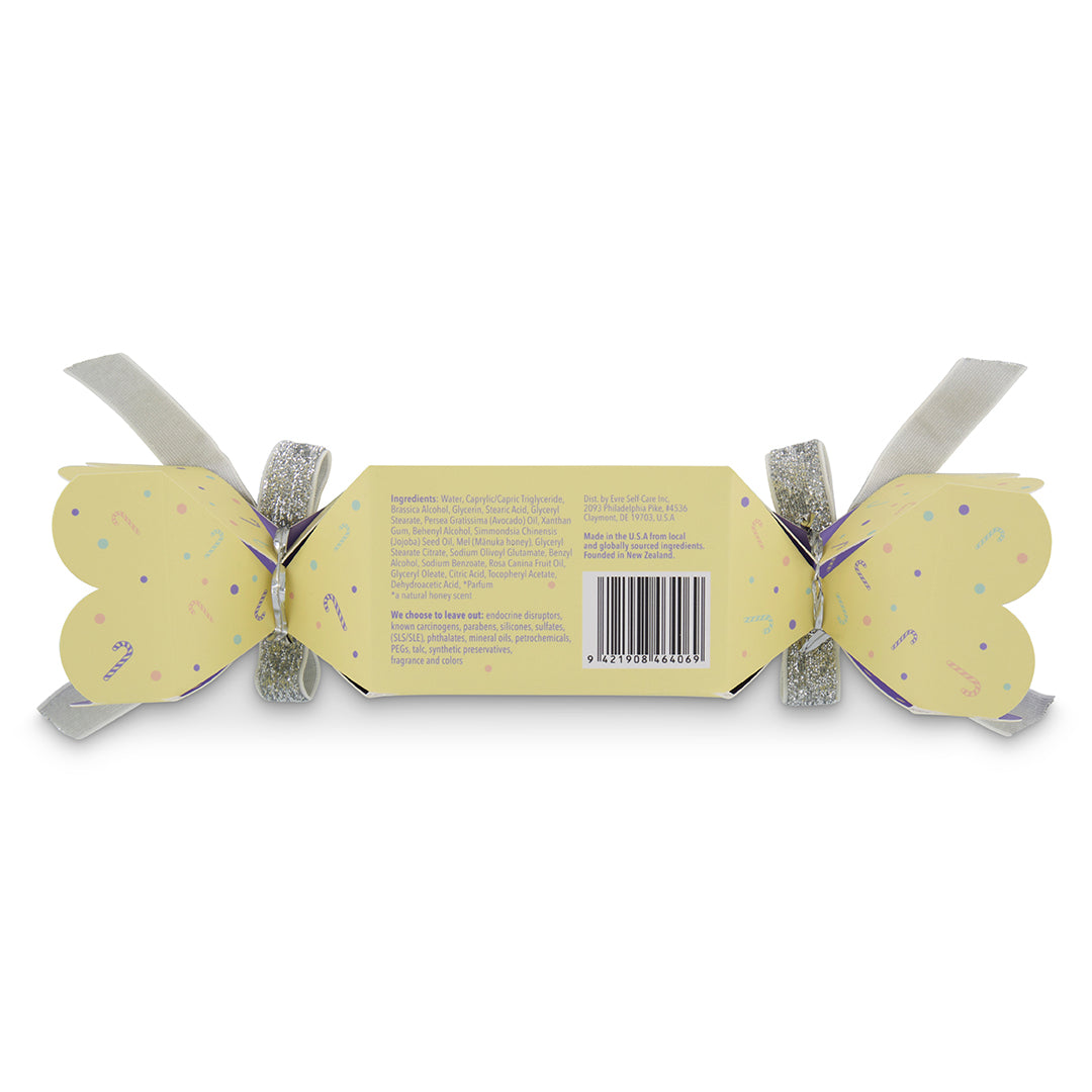 evre. | Super Nice Moisturizer Xmas Cracker | Back Packaging Image - back view of a yellow holiday cracker with pastel candy cane patterns, silver ribbons, ingredient details, and a barcode on a white background