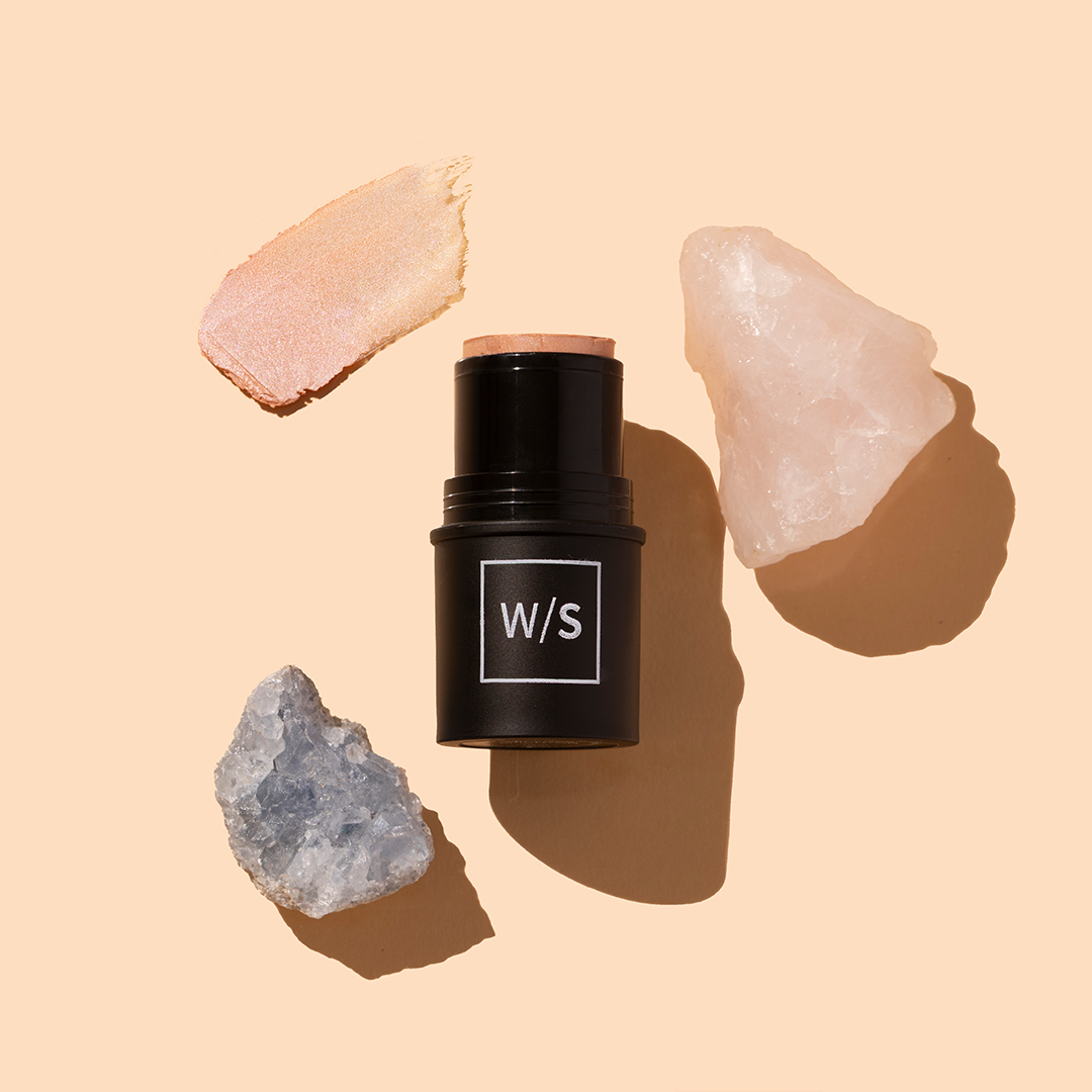 withSimplicity | Tri-Stick | Product Image with Swatch - cream stick in black tube with swatch and crystals on a beige background