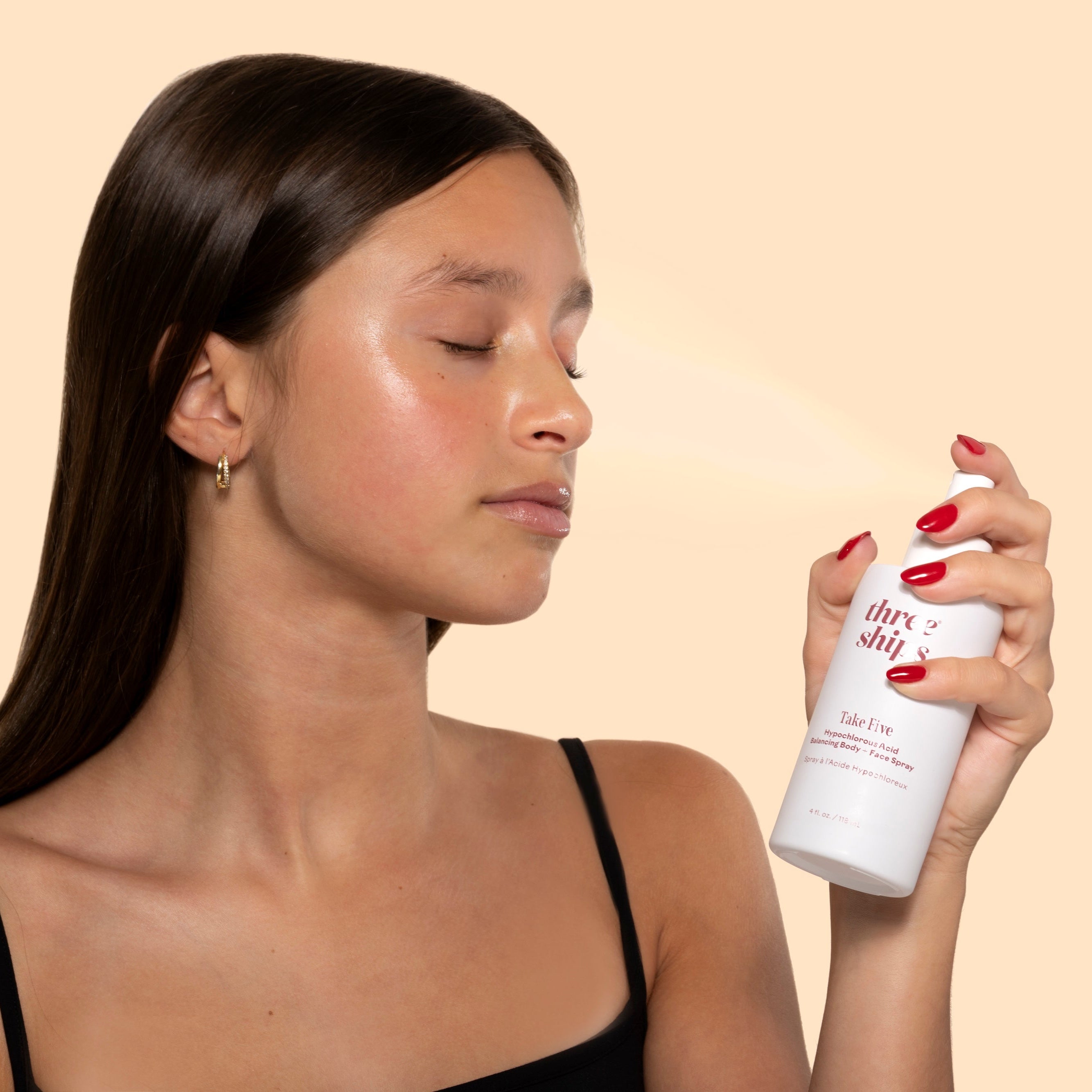 Three Ships | Take Five | Model holding white bottle misting on face 