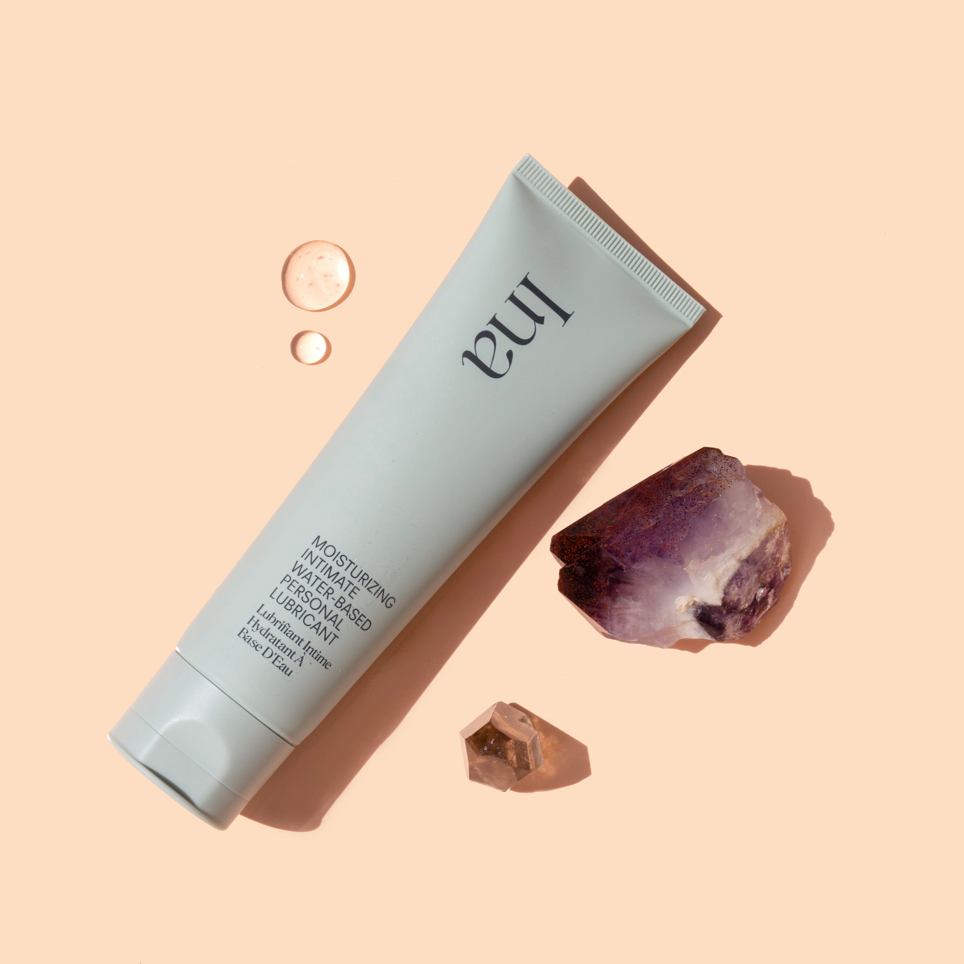 Ina personal lubricant tube with crystals on a beige background