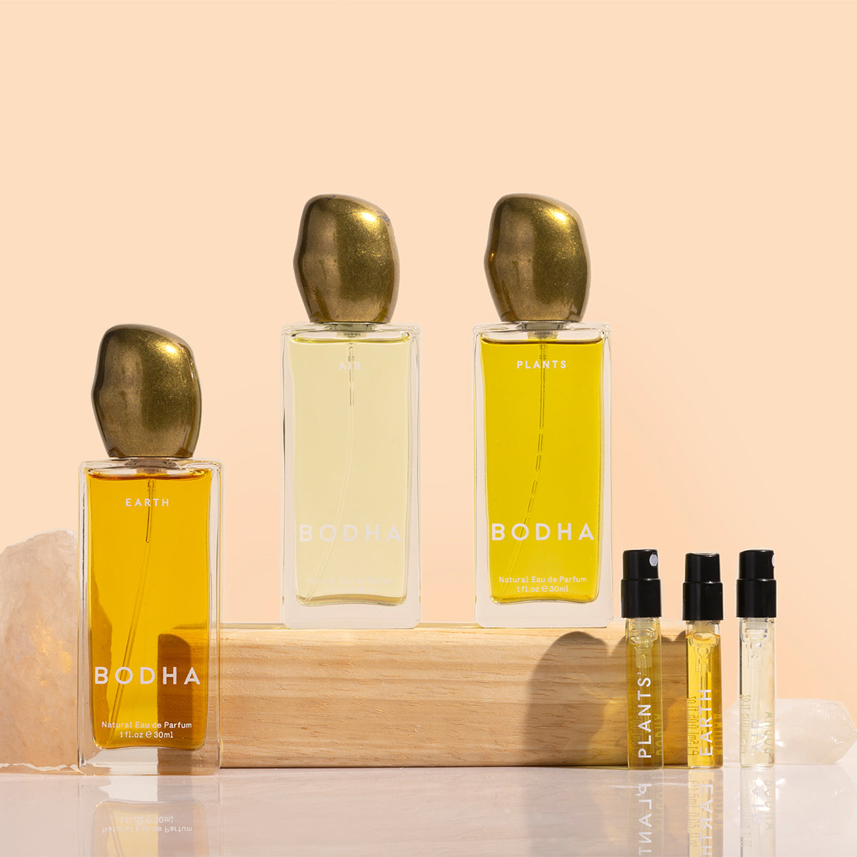 BODHA | Elemental Eau de Parfum Collection | Styled Image_Nov26 - BODHA Air, Earth, and Plants Eau de Parfum bottles displayed with three fragrance minis on a peach background