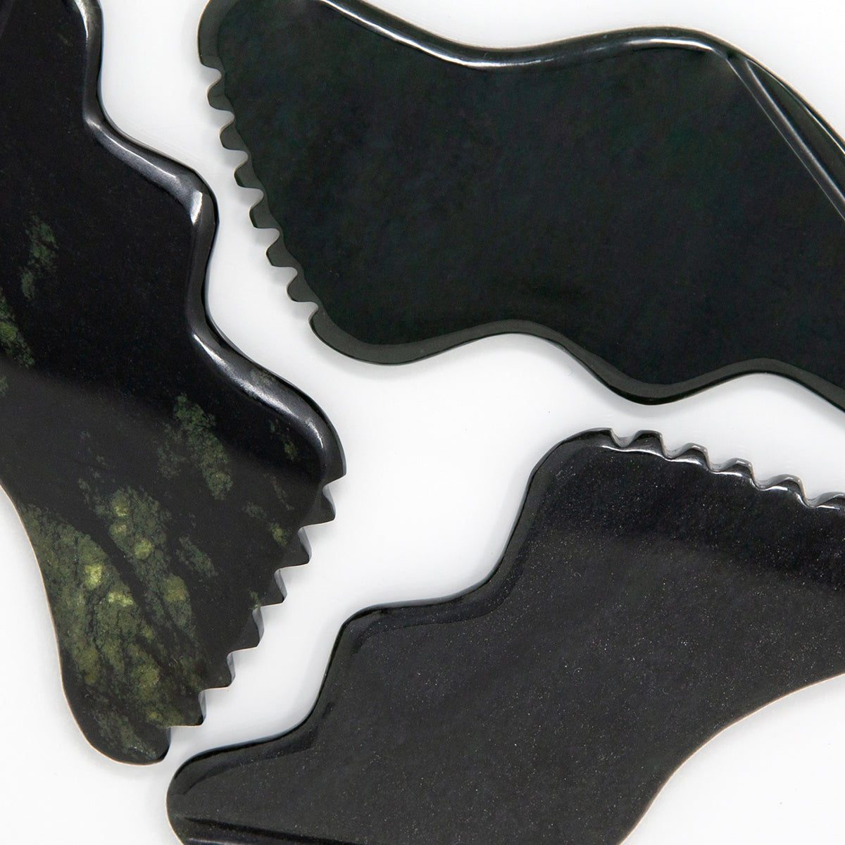 Cecily Braden | CJB Pro Nephrite | Multiple Image - close-up of dark nephrite gua sha tools showing their curved and scalloped edges