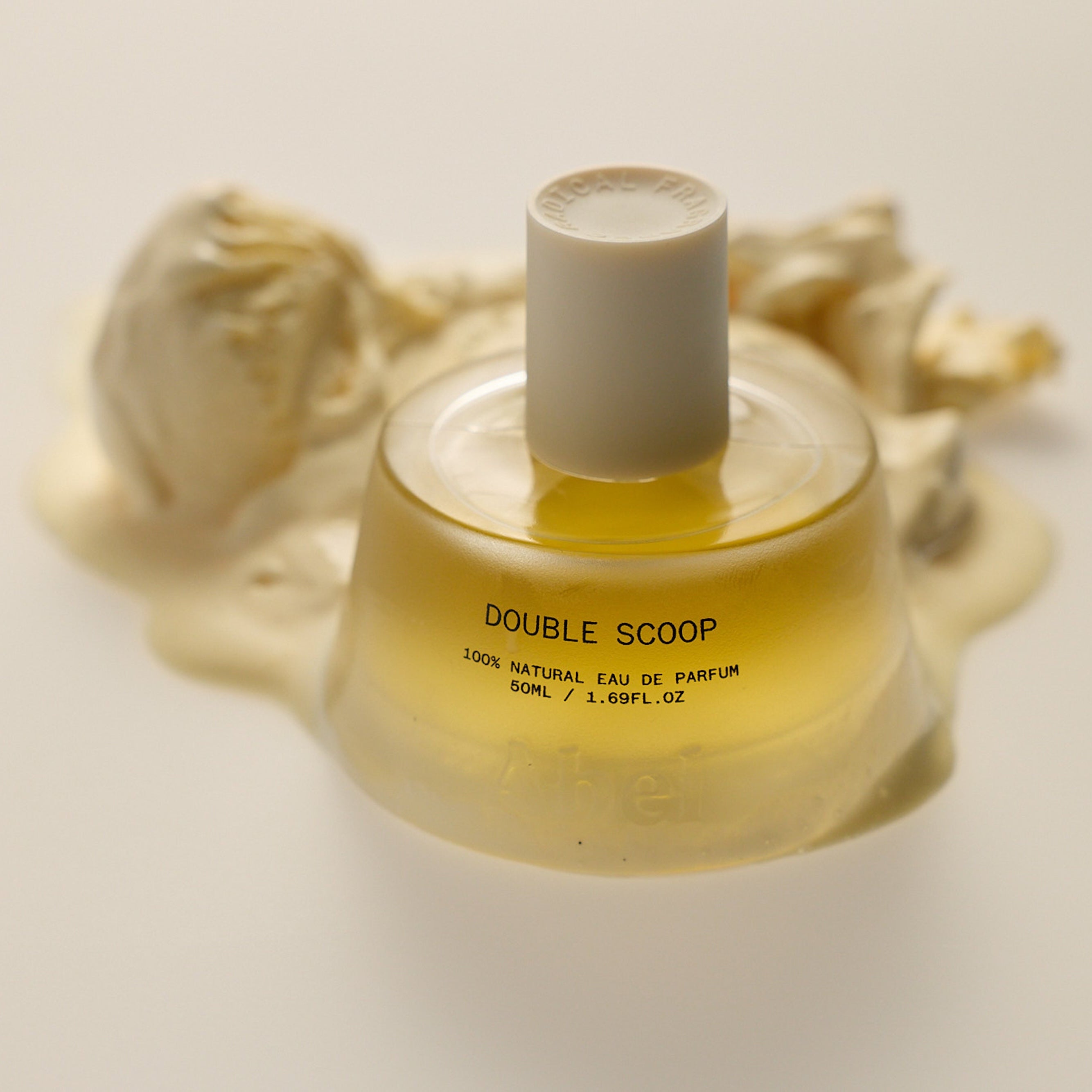 Abel | Double Scoop Eau De Parfum | Glass bottle with white top sitting on scoop of vanilla ice cream with white background 