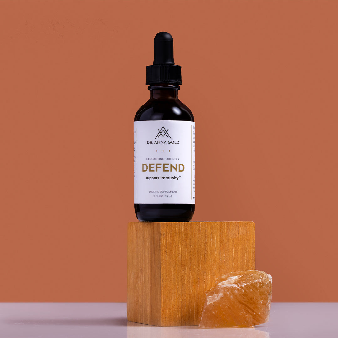 Dr. Anna Gold | Defend | Styled Image_Oct26 - tincture bottle on a wooden block with an amber crystal