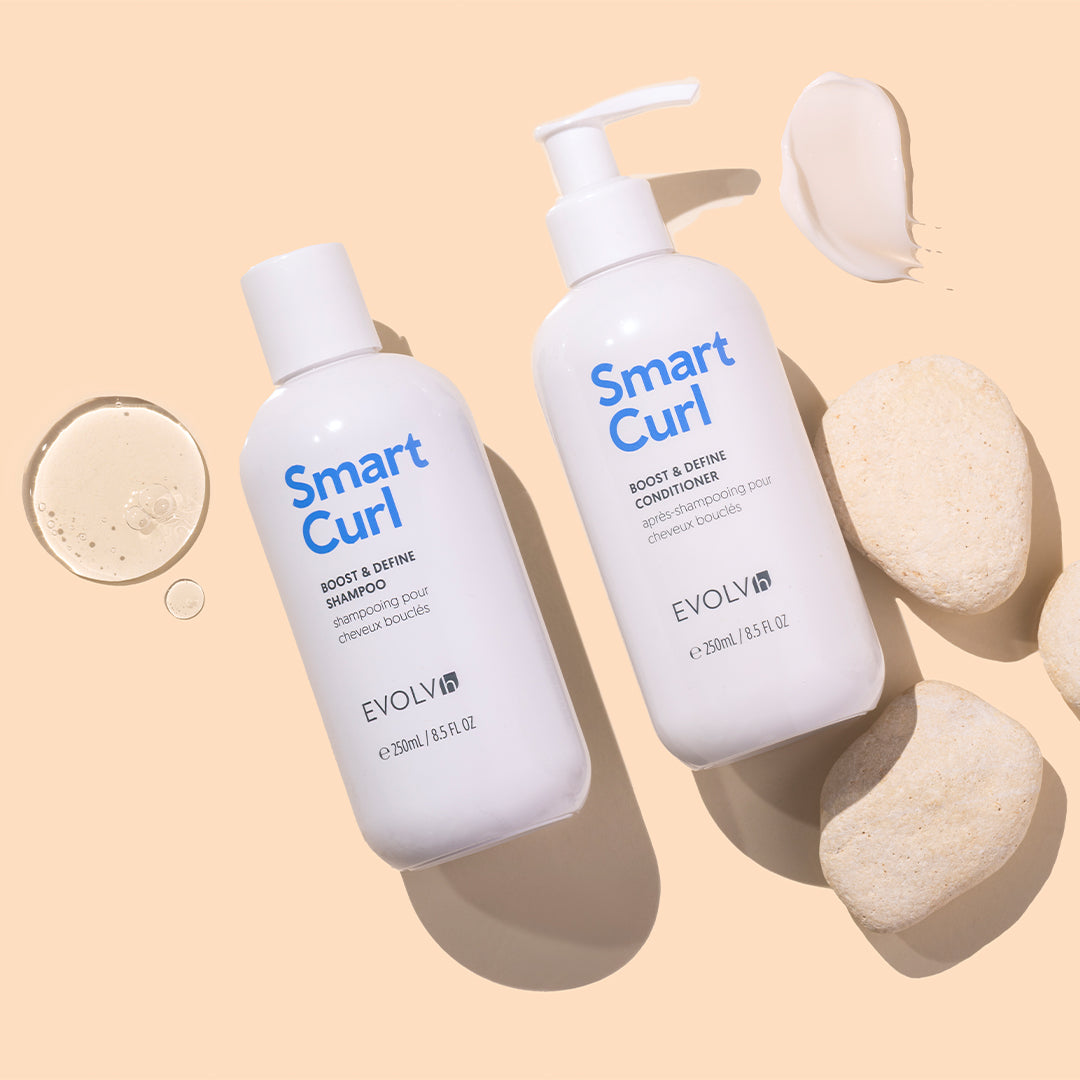 EVOLVh | SmartCurl Boost & Define Shampoo and Conditioner | Styled Image with Swatch_Aug26 - shampoo and Conditioner displayed with a gel droplet, cream swatch, and smooth stones on a beige background