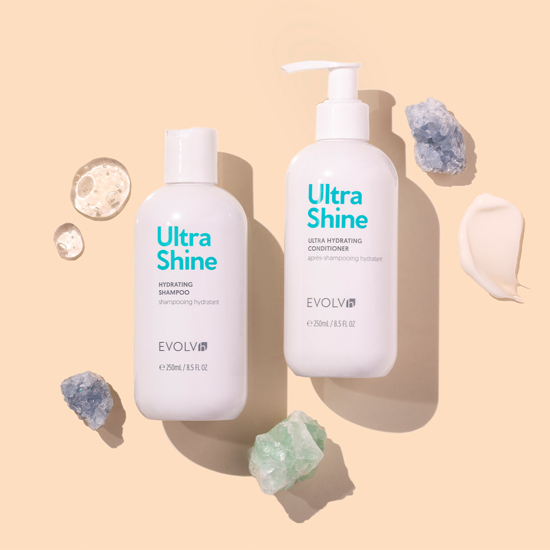 EVOLVh | UltraShine Hydrating Shampoo and Conditioner | Styled Image with Swatch_Aug26 - shampoo and conditioner displayed with gel bubbles, a cream swatch, and crystals on a beige background