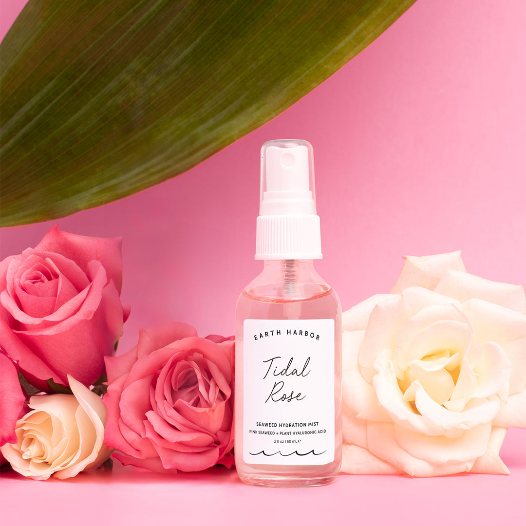 Earth Harbor | Tidal Rose Seaweed Hydration Mist | Lifestyle Image - mist bottle surrounded by pink and white roses against a pink background