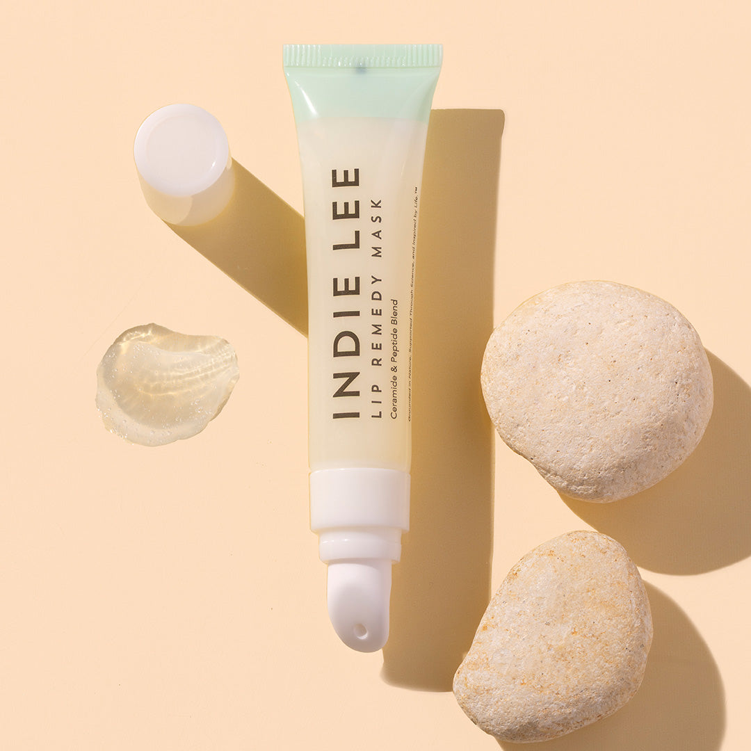 Indie Lee | Lip Remedy Mask | Product Image with Swatch - product tube laying on peach background with product swatch