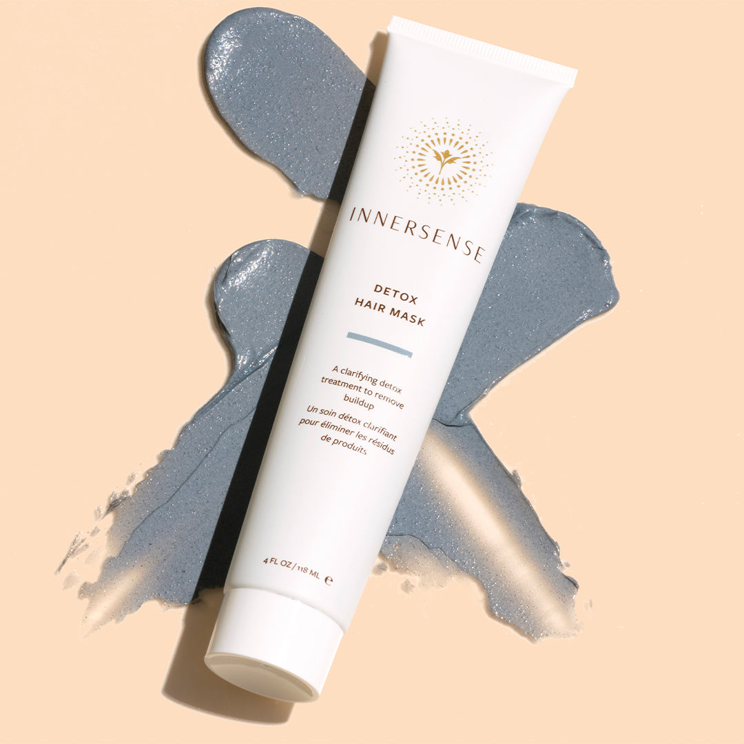Innersense Organic Beauty | Detox Hair Mask | Styled Image with Swatch - tube displayed over a gray clay smear on a soft beige background