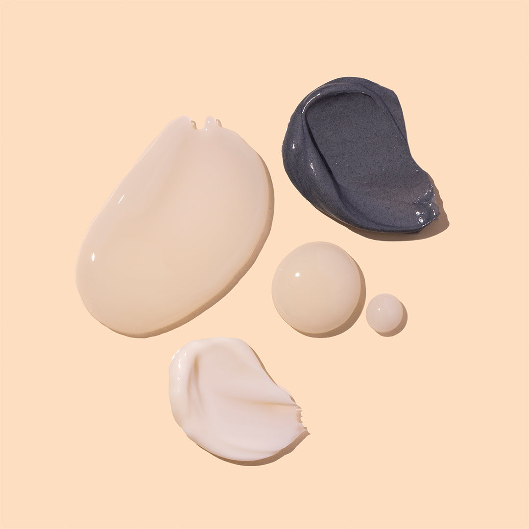 Innersense Organic Beauty | Discovery Box Collection | Swatch Image - texture swatches, including white creams, clear serum droplets, and a gray detox mask, displayed on a soft beige background