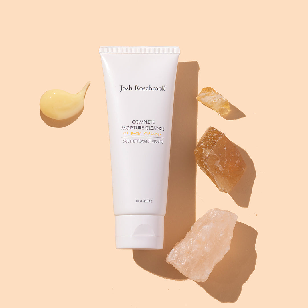 Josh Rosebrook | Complete Moisture Cleanse | Styled Image with Swatch - cleanser tube styled with cleanser swatch and crystals on a beige background