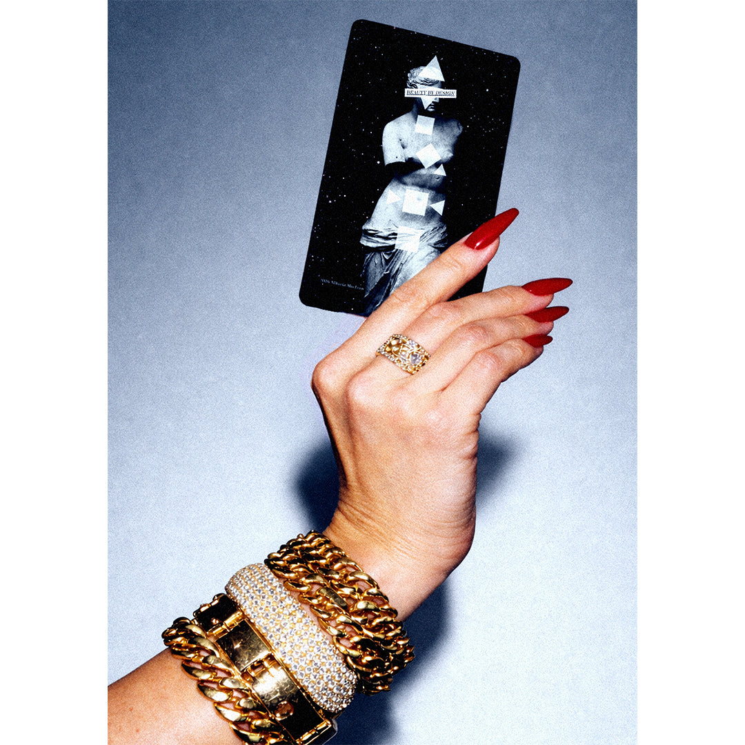 LILFOX | Beauty by Design Intuitive Beauty Oracle Cards in Hand | Product Image - hand holding a Beauty by Design Intuitive Beauty Oracle Card with gold jewelry and red nails