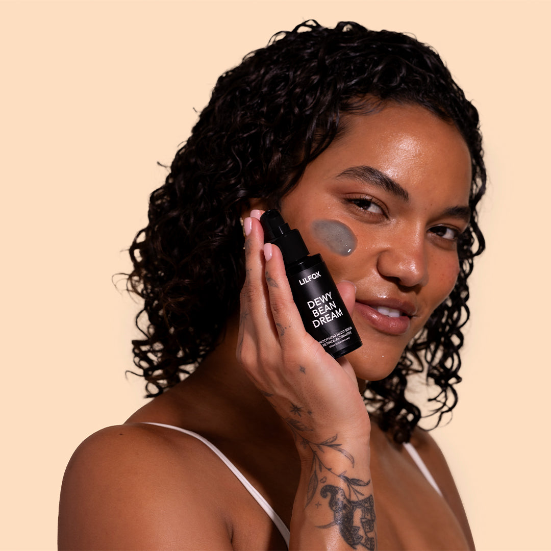 LILFOX | Dewy Bean Dream | Model Image_Jul26 - model holding moisturizer with a small amount applied to the cheek, showcasing the product's texture