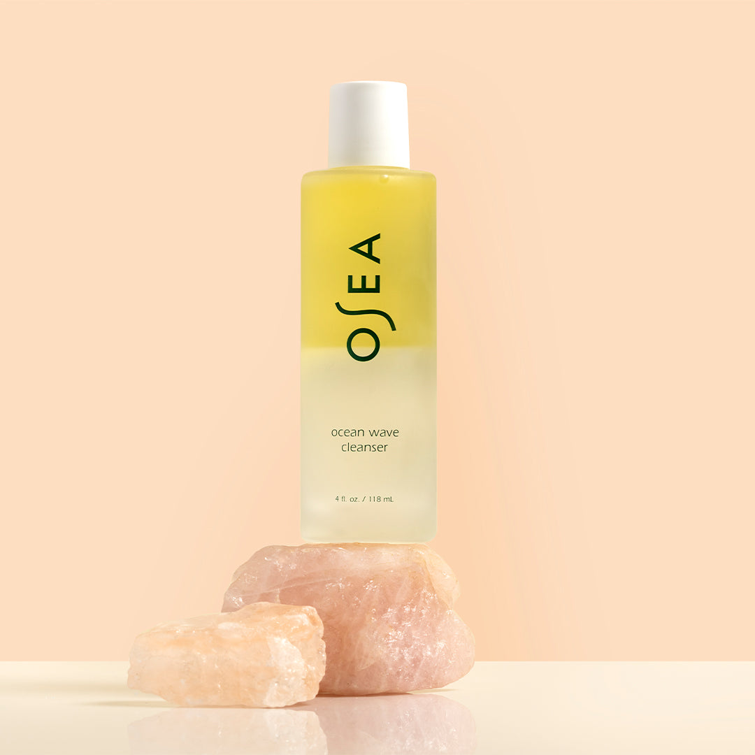 OSEA | Ocean Wave Cleanser | Styled Image_Sep26 - cleanser bottle on a peach background with crystals