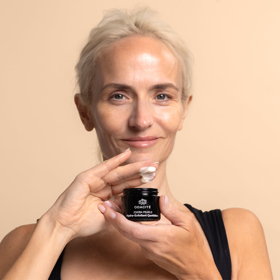 Odacite | Jojoba Pearls Daily Hydra-Exfoliant | Model Image_Sep26 - person holding black jar with cream texture visible