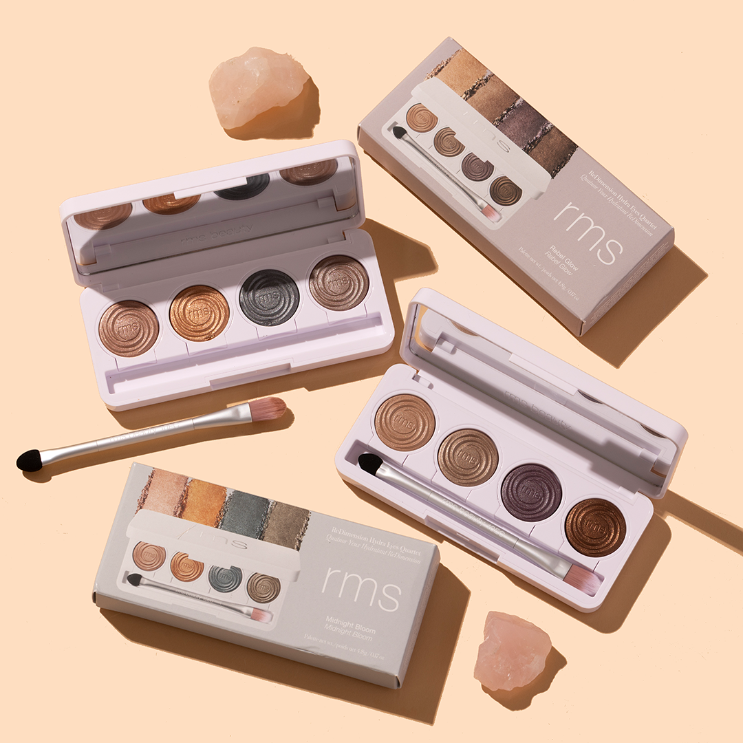 RMS Beauty | ReDimension Hydra Eyes Quartet | Product Image- eyeshadow quartets with open palettes, brushes, and boxes on a beige background