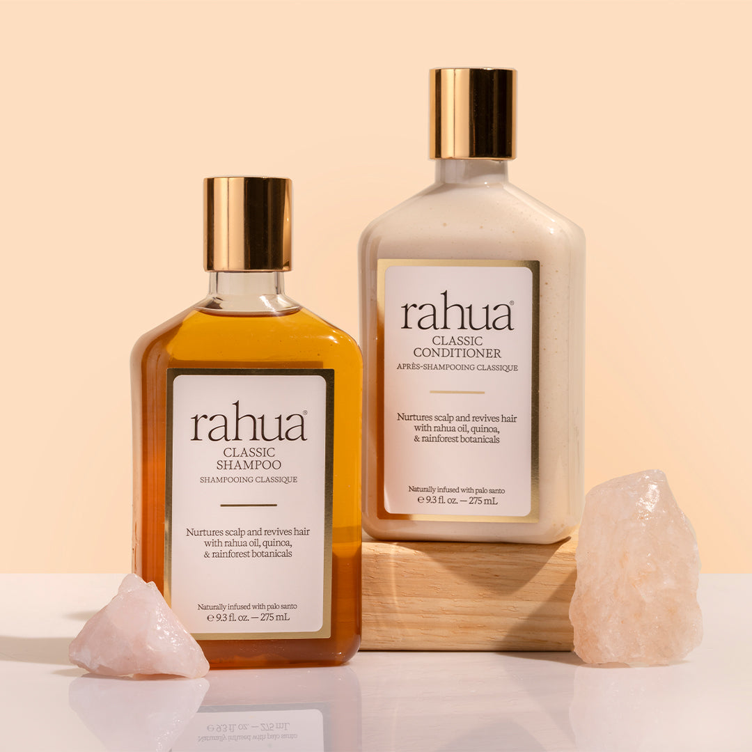 Rahua | Classic Shampoo and Conditioner | Product Image - 2 bottles with gold cap and crystals against a beige background