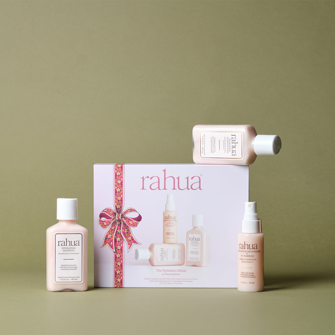 Rahua | The Hydration Ritual | Gift Set with Products - three travel-size haircare products arranged around a gift box on an olive green background