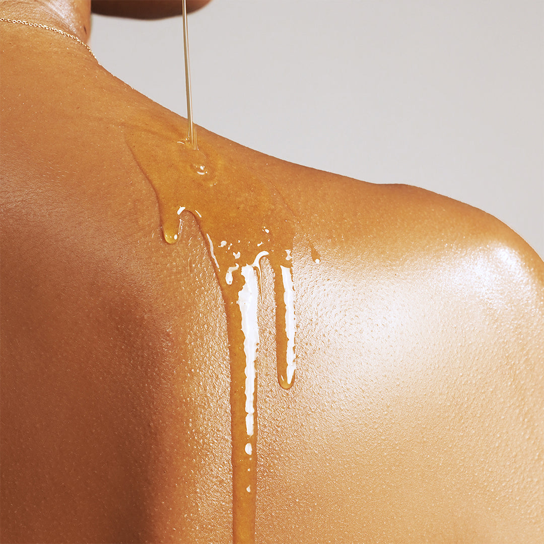 True Botanicals | Pure Radiance Body Oil | Shoulder Close-up Image - oil being poured onto a shoulder